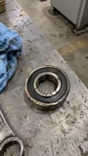 Phone photo of a worn 6205-2RS bearing on a shop workbench